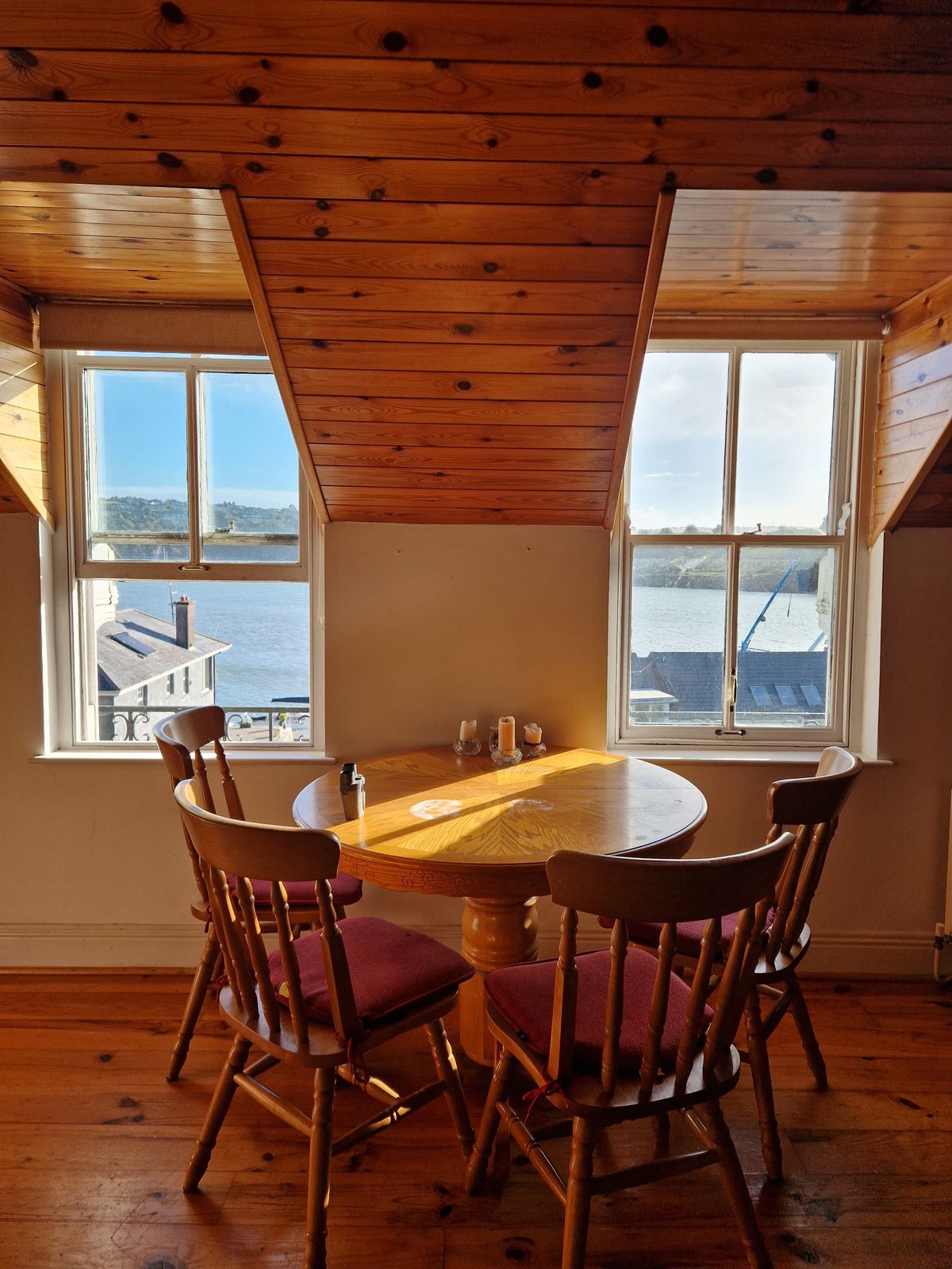 The dining table by the windows, looking out to sea