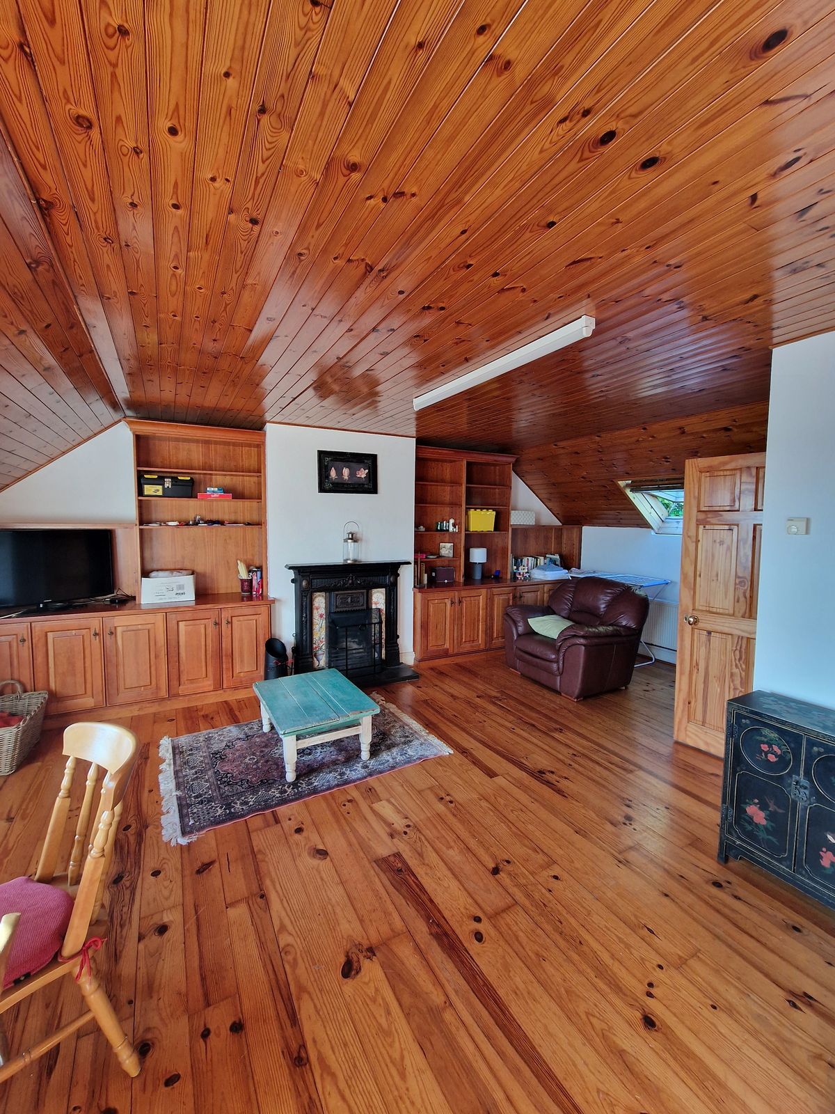 The living room, with its timber ceiling and fireplace